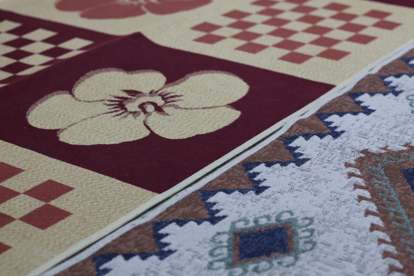 Bordo zeminli çiçek desenli halı ile kilim deseninin yan yana duruşu
