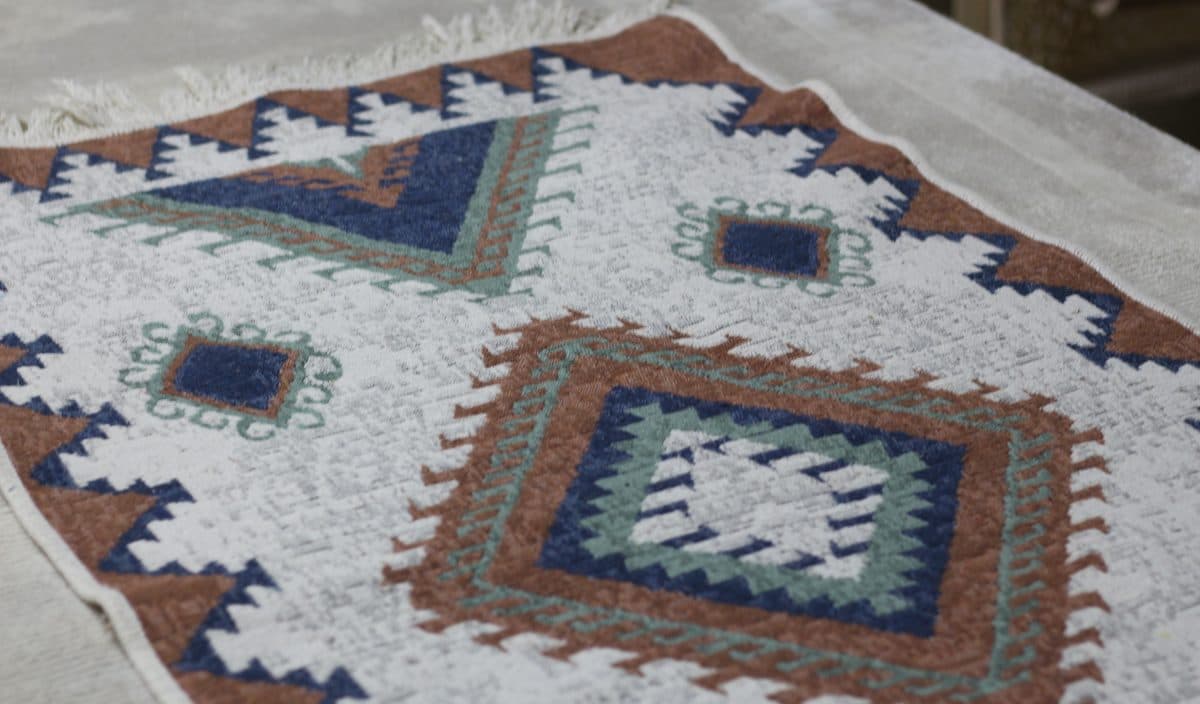 Yıkama öncesi hazırlık için tesis zeminine serilmiş, saçakları düzeltilmiş kilim